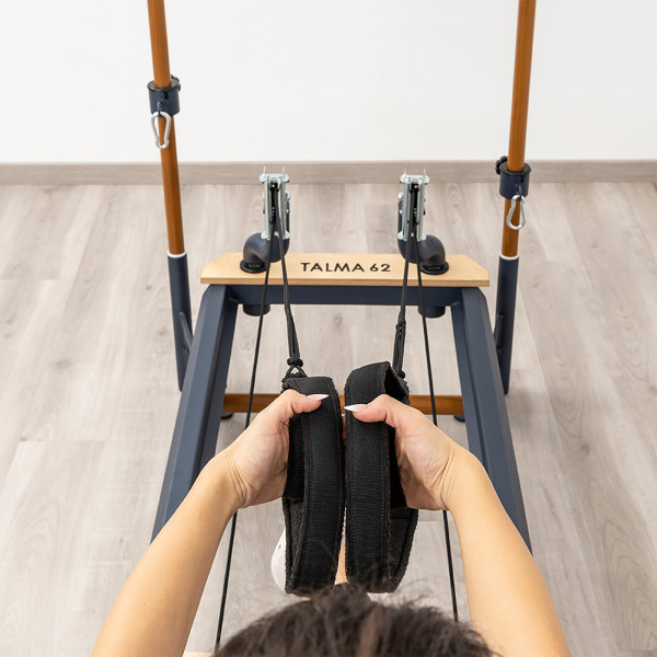 Close-up of a user holding double loop straps on the HEGREN TALMA 62CR Cadillac Reformer