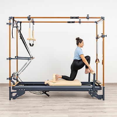 Hip flexor stretch with front foot on footbar on the HEGREN TALMA 62CR Cadillac Reformer