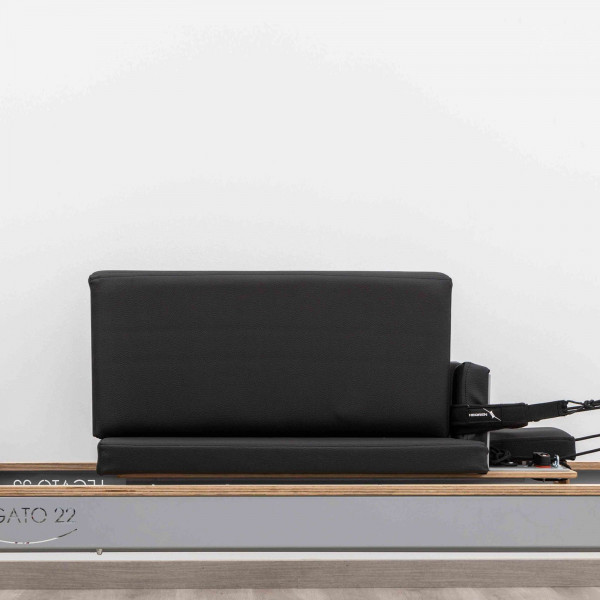 Side view of the HEGREN Modern Pilates Box in black on a reformer