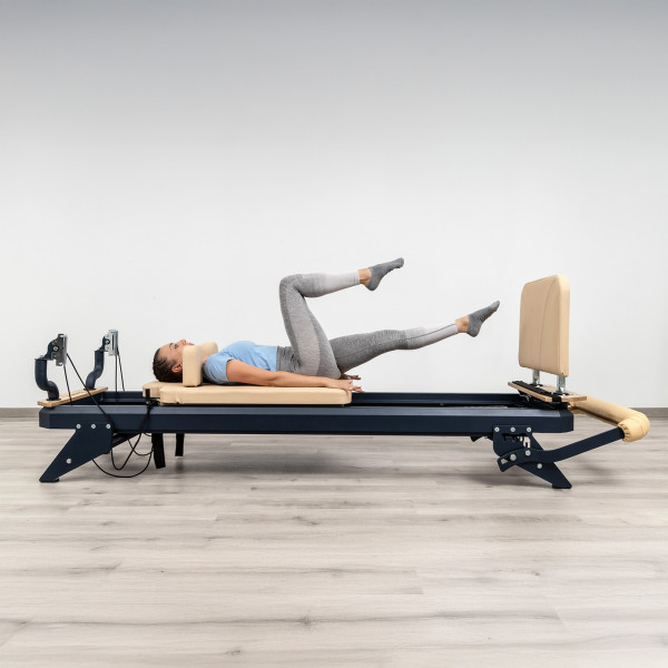 User performing single-leg footwork with jumpboard on HEGREN TALMA 62 Pilates Reformer
