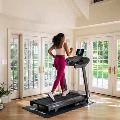A lifestyle image of a model running on the Horizon 5.0AT Treadmill