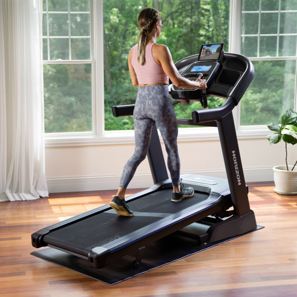 Person walking on the Horizon 7.4AT Treadmill.
