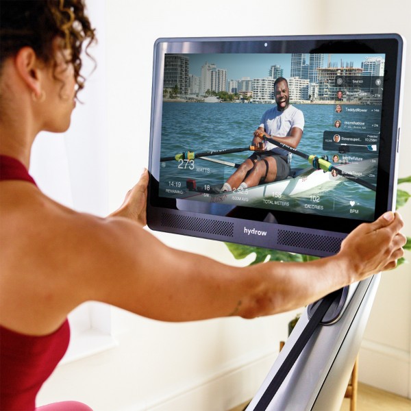 User adjusting the Hydrow Pro Rower console.