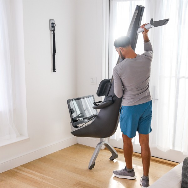 User storing away the Hydrow Pro Rower.