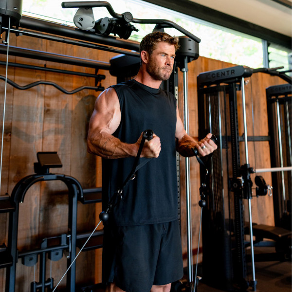 Chris Hemsworth doing a cable crossover exercise on the Inspire Fitness FT2 PRO Functional Trainer.