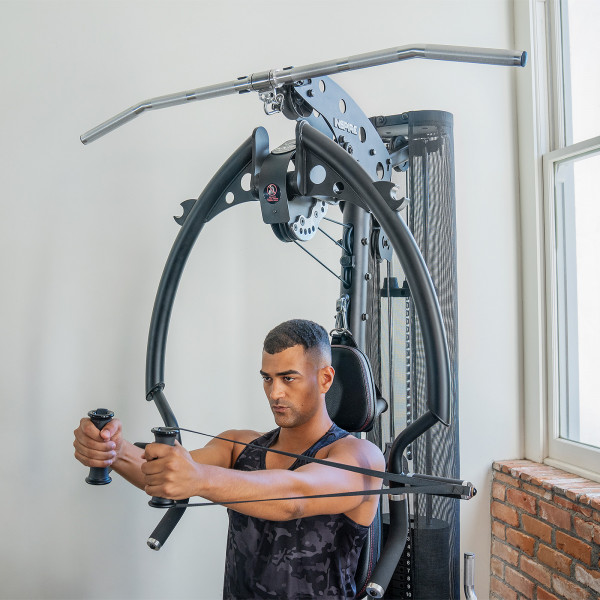A person using the cable system for a seated fly exercise on the Inspire Fitness M2 Multi-Gym
