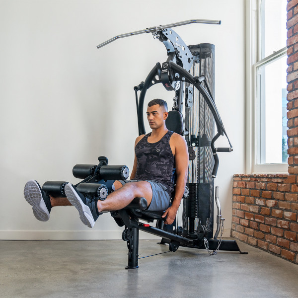A person doing a seated leg extension on the Inspire Fitness M2 Multi-Gym