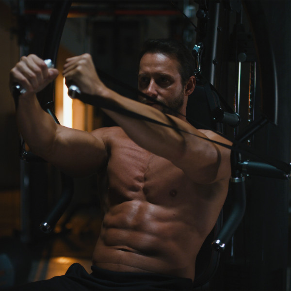 A person performing a chest press on the Inspire Fitness M5 Multi-Gym.
