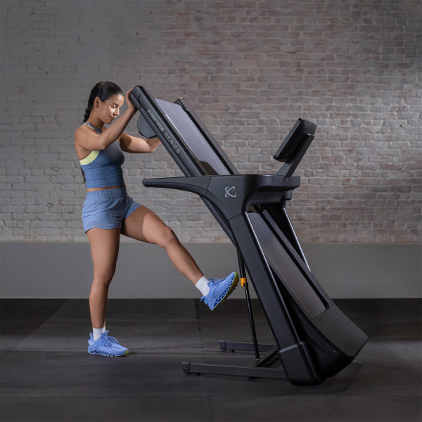 User folding the Inspire Fitness Series T5 Treadmill