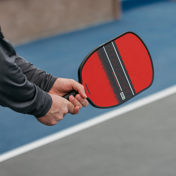 Hand holding the JOOLA Agassi Champion 12mm Pickleball Paddle.