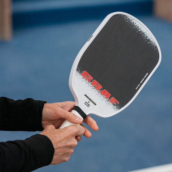 Hand holding the JOOLA Graf Edge 16mm Pickleball Paddle.
