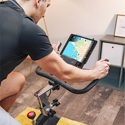 Model cycling indoors with a Kinomap GPS route displayed on a tablet