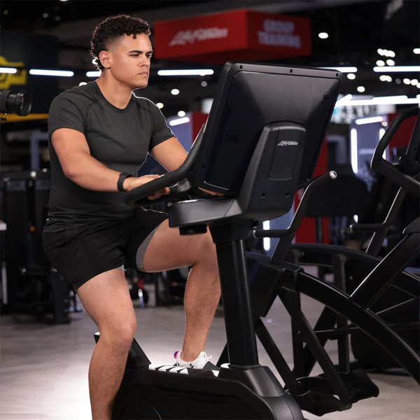 Person interacting with the console of the Life Fitness Club Series Plus Upright Exercise Bike.