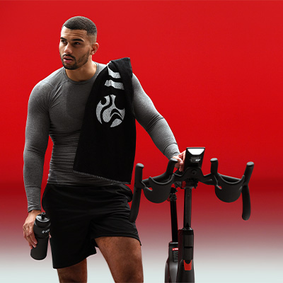 image of a model using a tablet with the IC7 whilst they ride. They also have a water bottle 