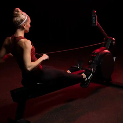 Rear angle of a model rowing on the Life Fitness Heat Performance Row