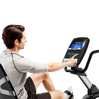 Model adjusting workout settings on the Marcy Pegasus Premium Home Recumbent Bike console 