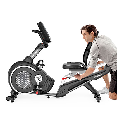 Model adjusting the seat position on the Marcy Pegasus Premium Home Recumbent Bike before a workout 