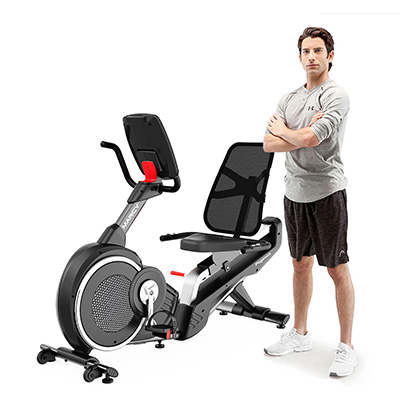 Model standing beside the Marcy Pegasus Premium Home Recumbent Bike for size reference 