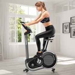 Model riding the Marcy Pursuit Premium Home Upright Bike in a home workout space