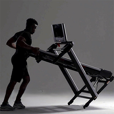 Model storing the Marcy Cross Country Power Fold Treadmill in folded position 