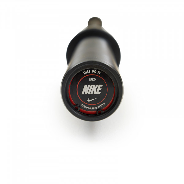 End cap view of the Nike Strength Premium Barbell 15kg in black, showing the "Just Do It" logo with performance details.