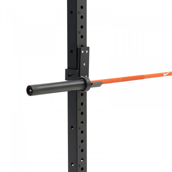 The Nike Strength Premium Barbell 15kg in orange mounted on a squat rack.
