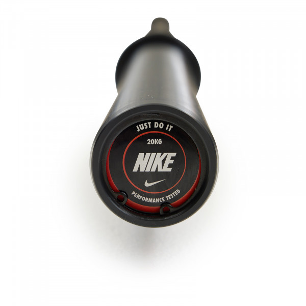 End cap view of the Nike Strength Premium Barbell 20kg in black, showing the "Just Do It" logo with performance details.