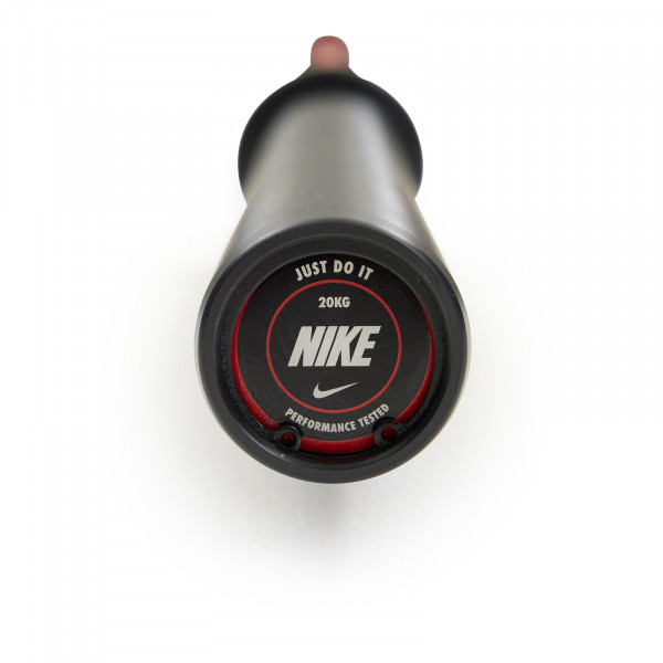 End cap view of the Nike Strength Premium Barbell 20kg in red, showing the "Just Do It" logo with performance details.
