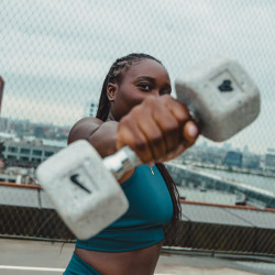 Lifestyle image of a model holding a grind dumbbell