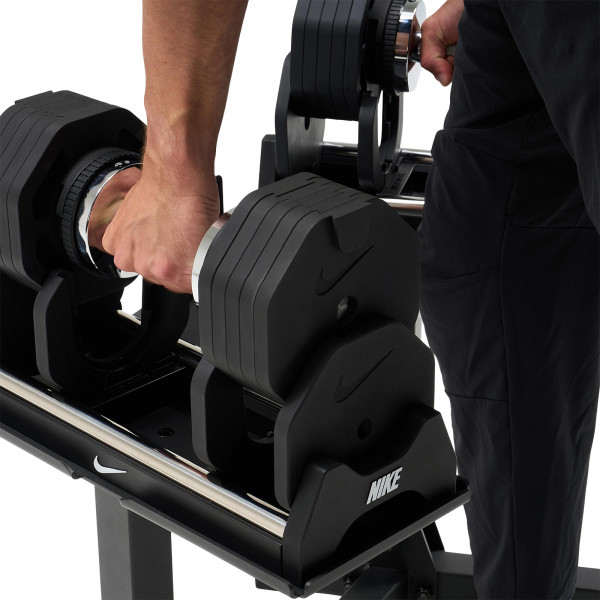 Image of a model grabbing the adjustable dumbbells