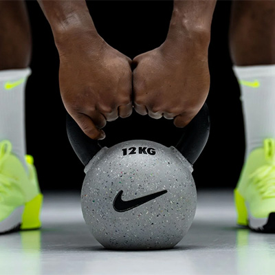 Photograph of the Nike Strength Rubber Coated Kettlebell being held by a model.