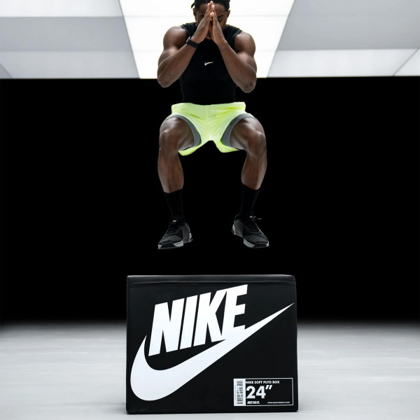 Model performing a box jump on the Nike Strength Soft Plyo Box in black