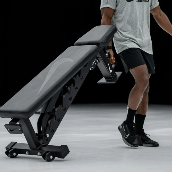 Person moving the Nike Strength Adjustable Weight Bench with handle and wheels