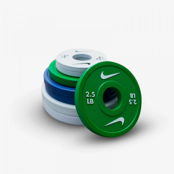 A stack of Nike Strength Change Plates in green, blue, and white.