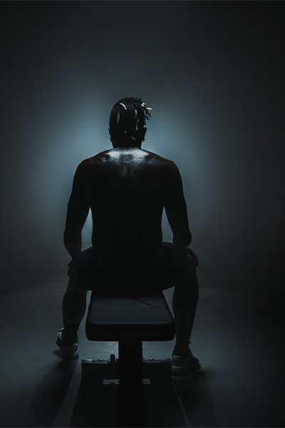 Model seated on a bench in low light