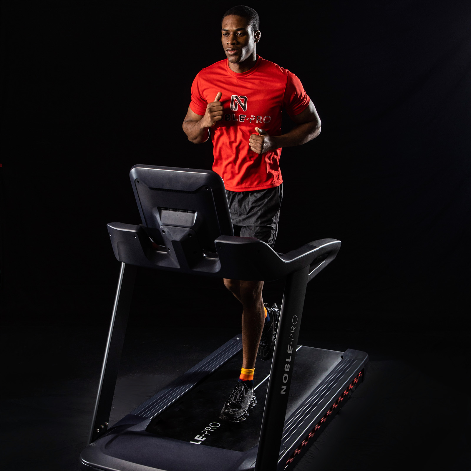 Angled front view of the model running on the NoblePro Elite E10i Treadmill 