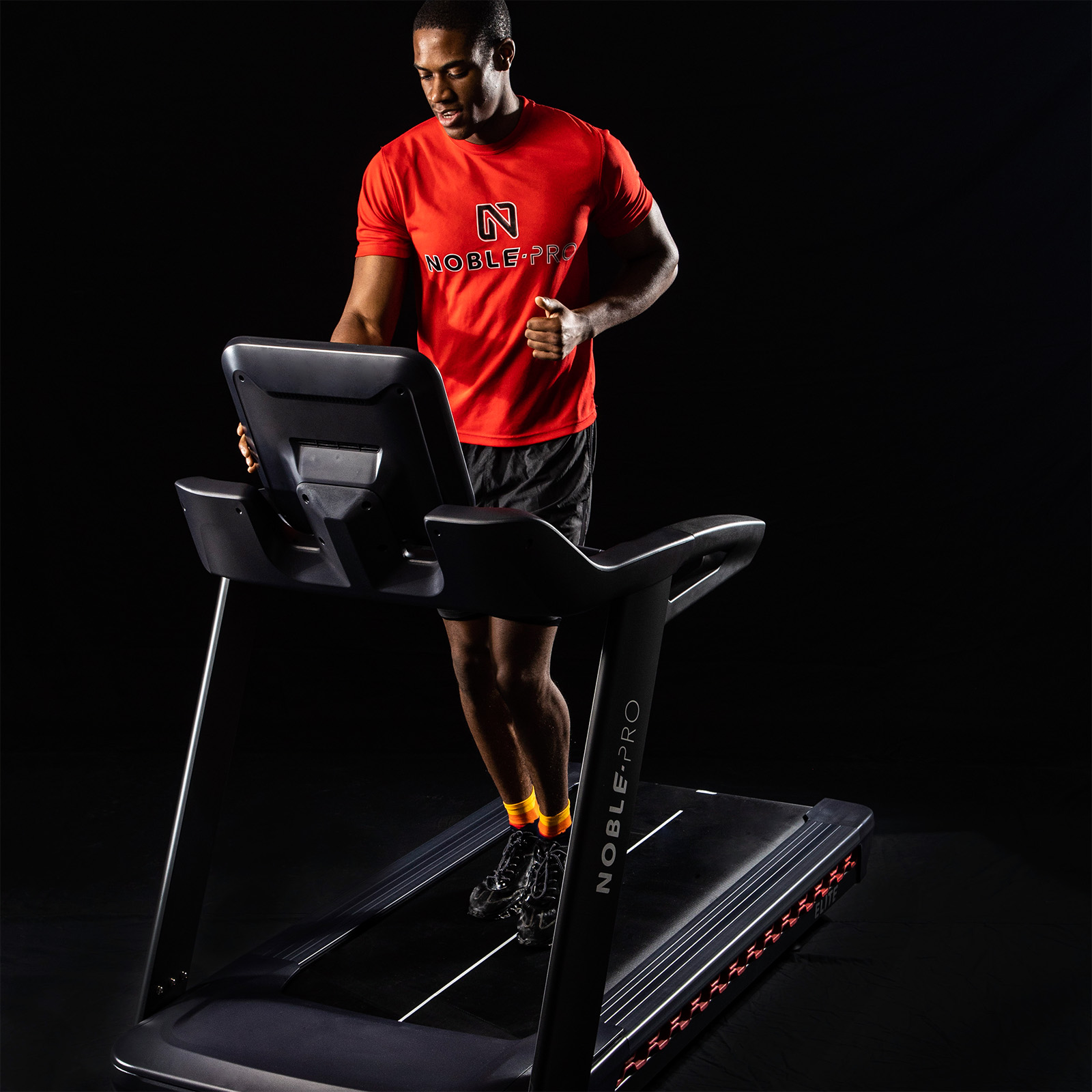 Model adjusting the touchscreen while walking on the NoblePro Elite E10i Treadmill 