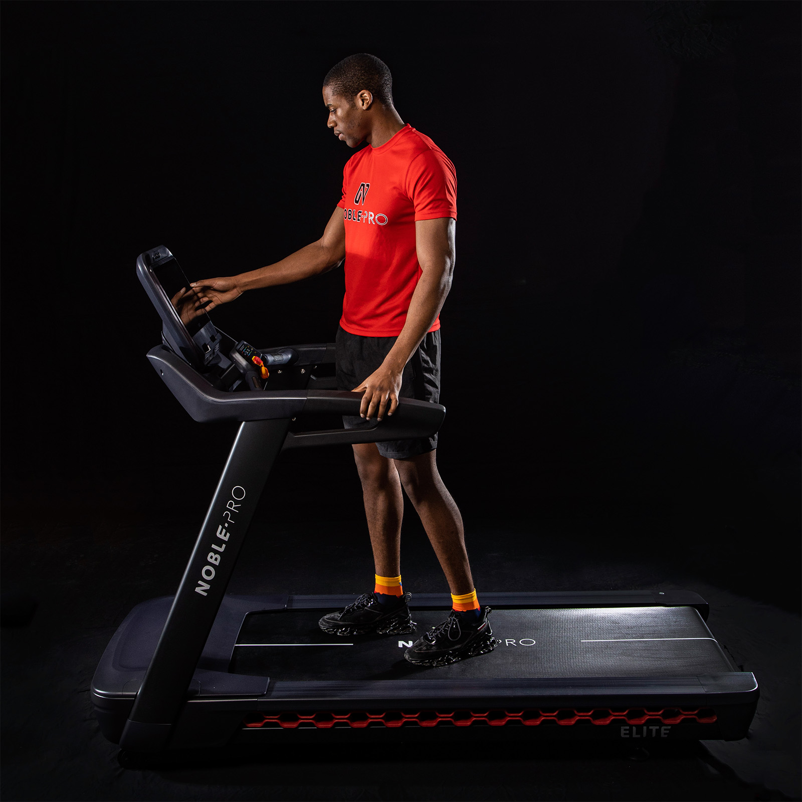 Model using the touchscreen on the NoblePro Elite E10i Treadmill 