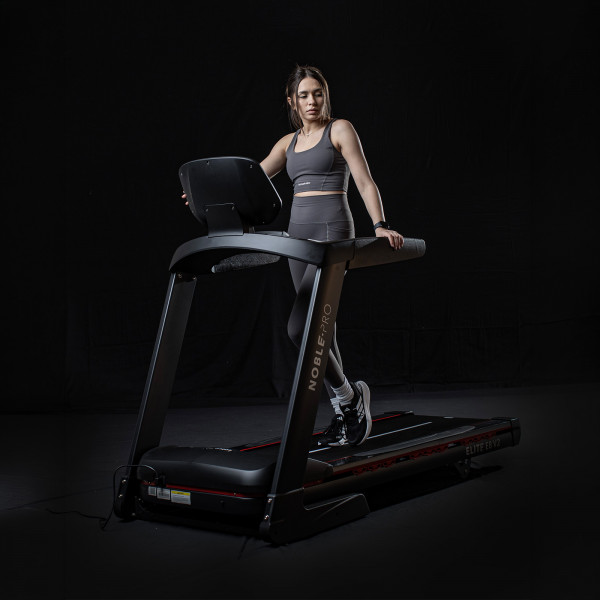 Model standing on the NoblePro Elite E8ix Treadmill