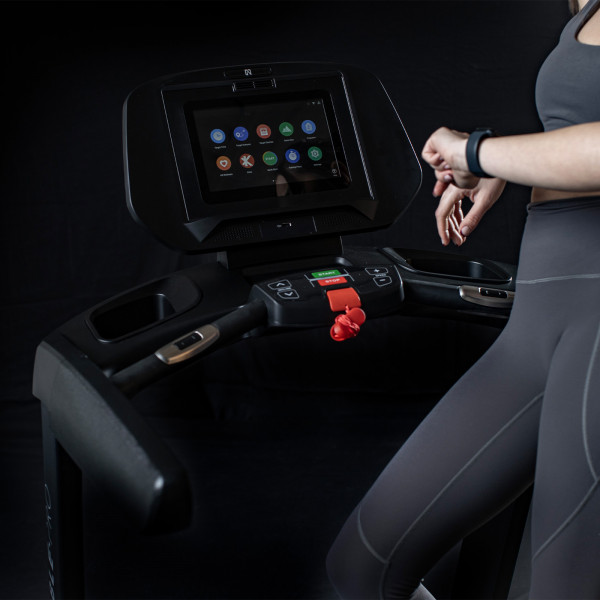Model adjusting the touchscreen on the NoblePro Elite E8ix Treadmill