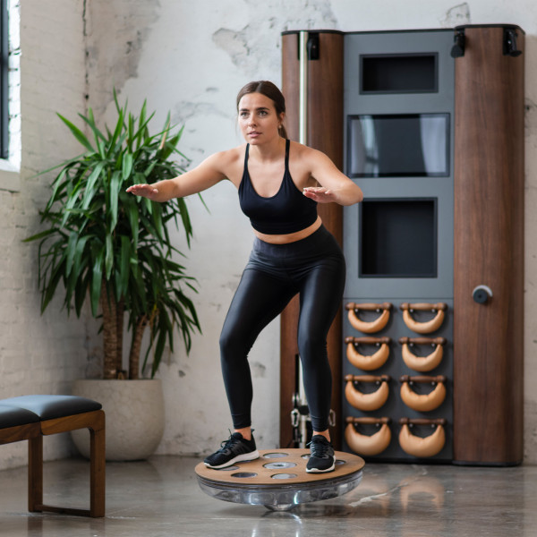 Person practising balance on the NOHRD Eau-Me Board indoors