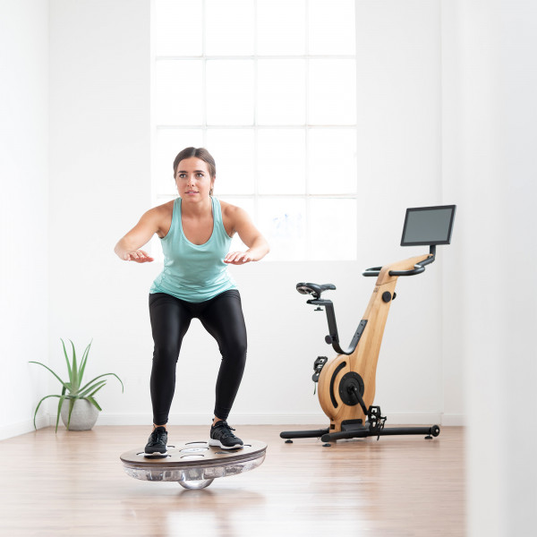 Person doing a squat on the NOHRD Eau-Me Board indoors