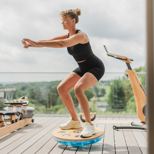 Person performing a squat on the NOHRD Eau-Me Board outdoors