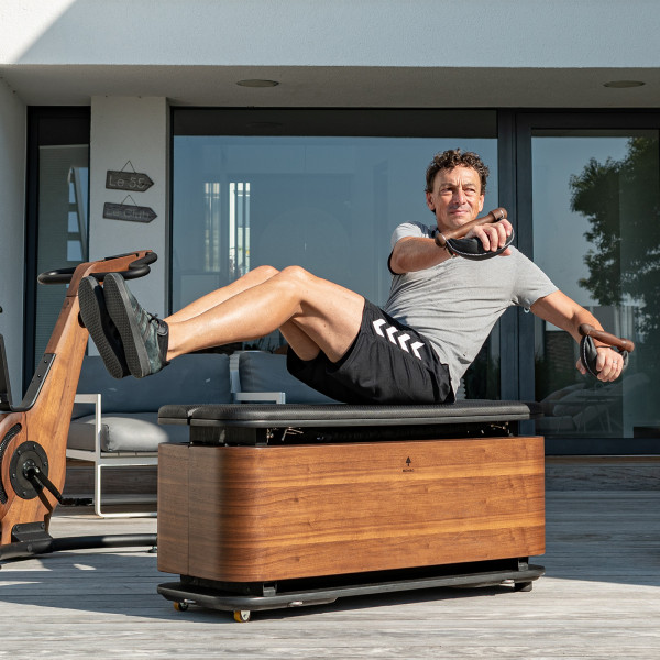 User performing seated twist with SwingBells on NOHRD StepBox.
