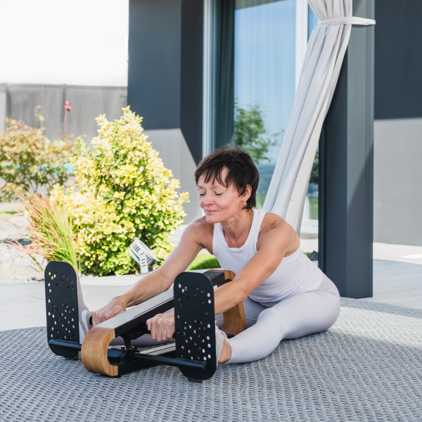 User stretching with the NOHRD SpineStretch outdoors.