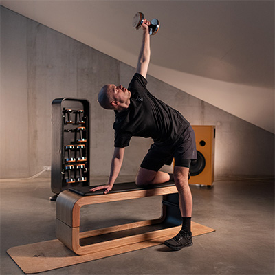 Person performing dumbbell rotation exercise on bench