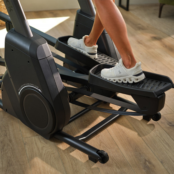 Close-up of feet on the NordicTrack X16 Elliptical pedals showing the incline movement
