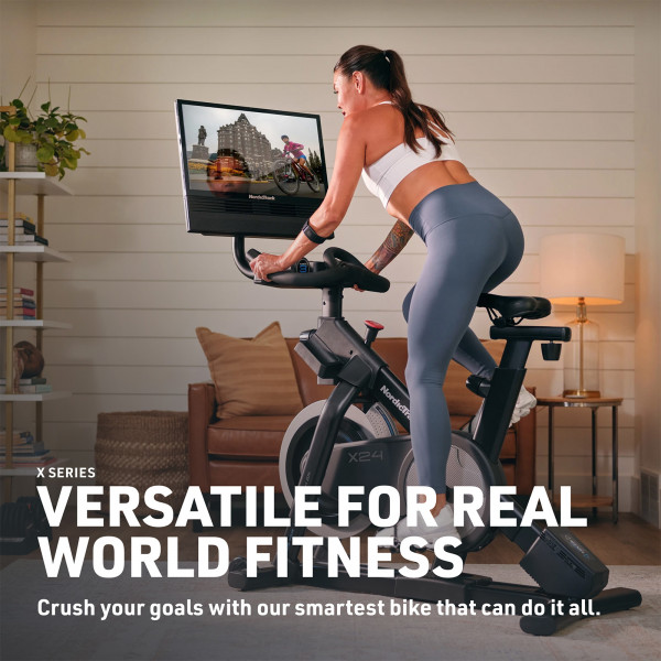 Model riding the NordicTrack X24 Bike in a home setting with workout display on screen
