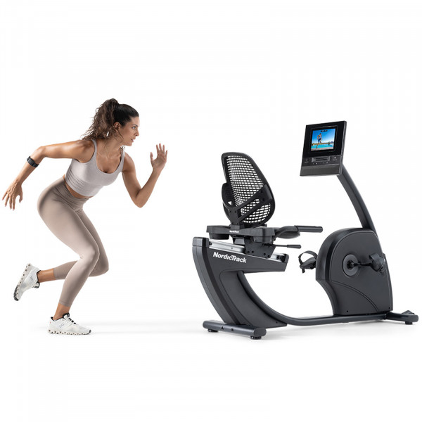 Person doing exercises next to the NordicTrack 10 Recumbent Bike with a workout displayed on the screen.