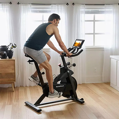 User cycling on the NordicTrack T Series 9 Bike in home setting